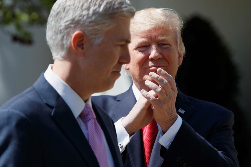 President Donald Trump applauds new Supreme Court Justice Neil Gorsuch during a public swearing-in ceremony for Gorsuch in the Rose Garden of the White House in Washington on April 10, 2017. (Associated Press) **FILE**