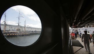 The tall ship Oliver Hazard Perry, top left, is viewed through a porthole on the Peruvian Navy tall ship Union as passers-by, right, walk along a deck aboard the Union during the Sail Boston event, Sunday, June 18, 2017, in Boston. More than 50 tall ships from Europe, South America and the U.S. converged on the city as part of the Rendez-Vous 2017 Tall Ships Regatta. (AP Photo/Steven Senne)