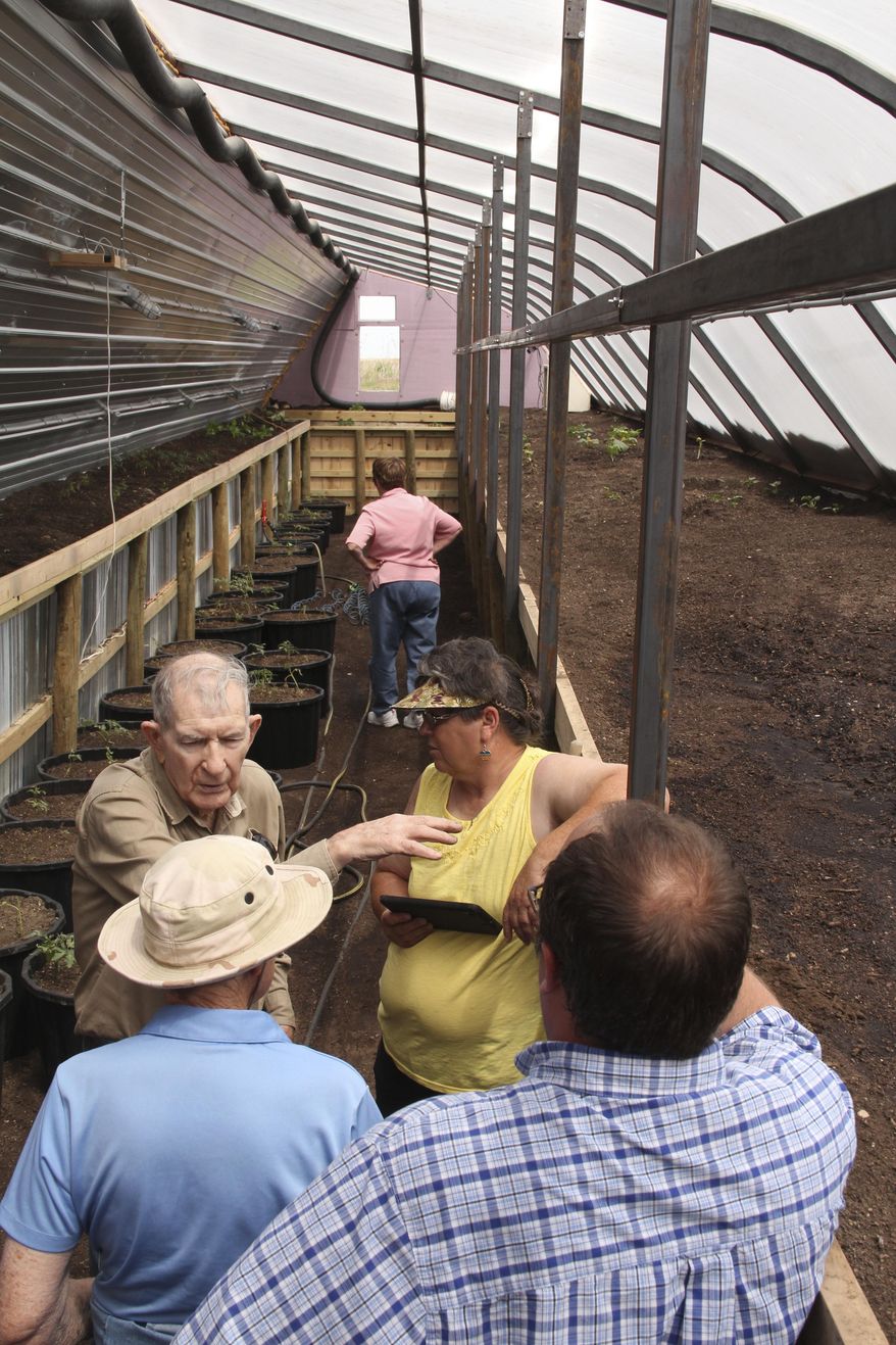 In this June 9, 2017 photo, members of the Nebraska Master Gardener Program get the opportunity to explore one of Russ Finch's newer greenhouses outside of Alliance, Neb. Finch has created greenhouses that run on geothermal heat. Geothermal heat produces heat from the ground through a singular heat source that dispenses heat through a tubing system. He began selling his geothermal greenhouses with his business Greenhouse in the Snow about three years ago. (Torri Brumbaugh/The Star-Herald via AP)