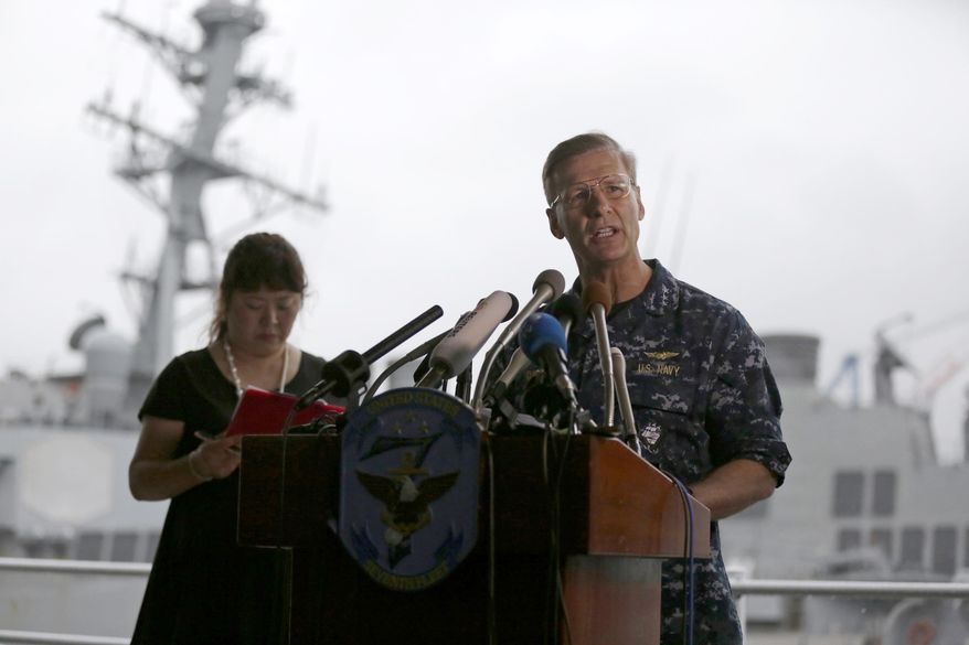 Vice Adm. Joseph Aucoin, right, Commander of the U.S. 7th Fleet, speaks during a press with damaged USS Fitzgerald as background at the U.S. Naval base in Yokosuka, southwest of Tokyo Sunday, June 18, 2017. The U.S. destroyer Fitzgerald collided with a container ship in the busy sea off Japan, Saturday. (AP Photo/Eugene Hoshiko)