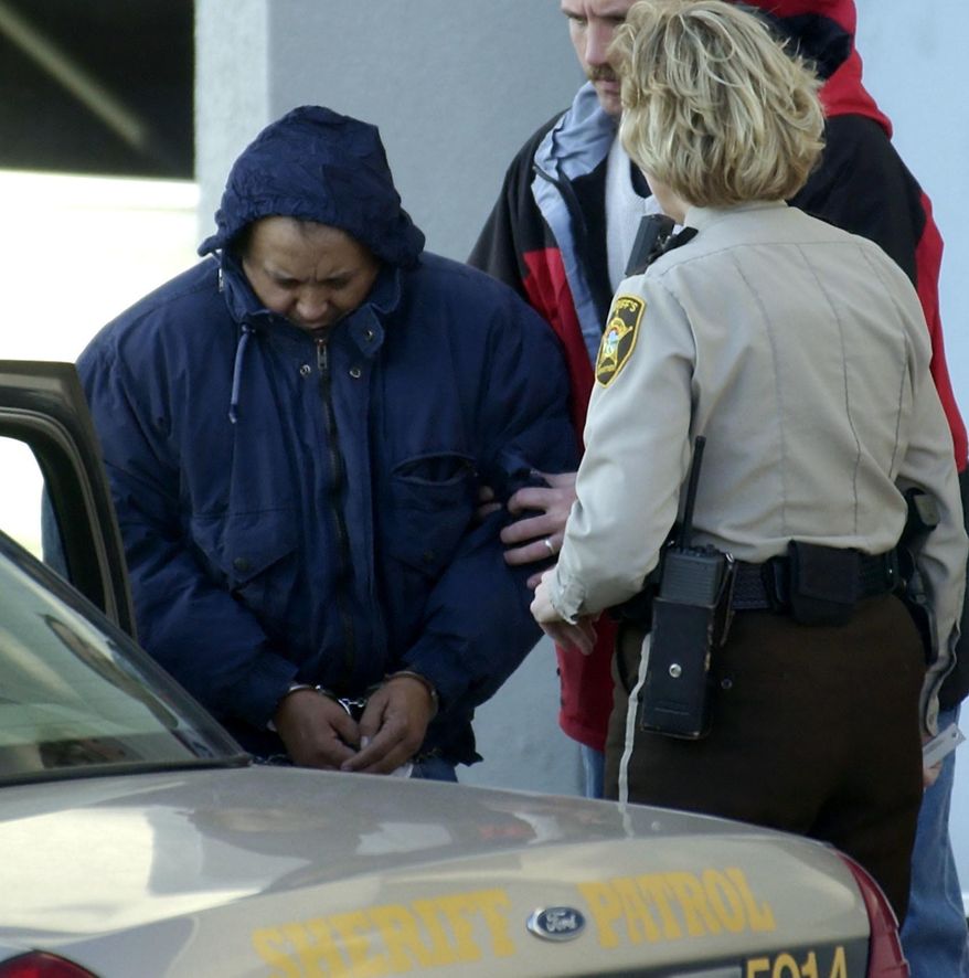 FILE - In this Dec. 3, 2003 file photo, Alfonso Rodriguez Jr., left, is helped into a sheriff's car after waiving extradition at the Polk County Courthouse in Crookston, Minn. A hearing is scheduled for Tuesday, June 20, 2017 in the appeal of Rodriguez's death sentence for killing University of North Dakota student Dru Sjodin. Rodriguez has been on death row in federal prison since 2003. (AP Photo/Ann Heisenfelt File)
