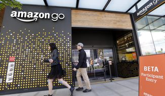 FILE - In this Thursday, April 27, 2017, file photo, people walk past an Amazon Go store, currently open only to Amazon employees, in Seattle. Amazon Go shops are convenience stores that don&#39;t use cashiers or checkout lines, but use a tracking system that of sensors, algorithms, and cameras to determine what a customer has bought. Amazon says the company has no plans to use such sensors to automate the cashier jobs at Whole Foods, which Amazon is acquiring. Still, it’s the kind of technology that could help cut costs down the road, and that others may look to as well. (AP Photo/Elaine Thompson, File)