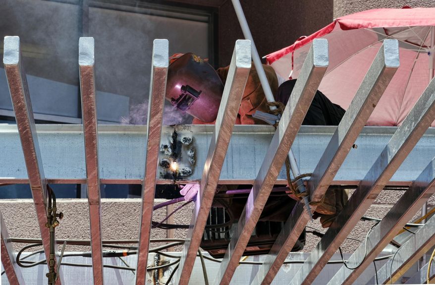 A construction worker welds a steel awning in the heat of the afternoon sun on a building in downtown Los Angeles on Monday, June 19, 2017. A heatwave in the southwest and California is creating a public health hazard. (AP Photo/Richard Vogel)