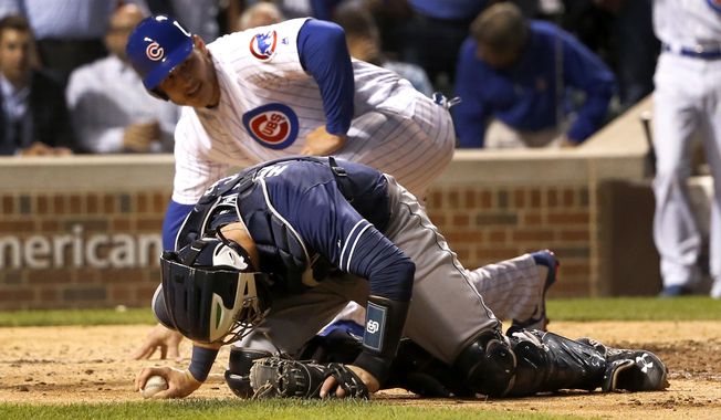 San Diego Padres catcher Austin Hedges stays on the ground after tagging out Chicago Cubs&#x27; Anthony Rizzo during a collision at home during the sixth inning of a baseball game Monday, June 19, 2017, in Chicago. (AP Photo/Charles Rex Arbogast)