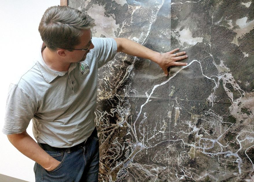 Bret Howser, Brian Head's town manager, shows the area on a map north of town where a wildfire burns, Sunday, June 18, 2017, in Brian Head, Utah. Firefighters were hoping to have a blaze near a southwestern Utah ski town 10 percent contained by Sunday. Some 750 residents and visitors have been evacuated. No injuries have been reported.Leah Hogsten /The Salt Lake Tribune via AP)