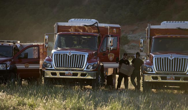 Firefighting crews get ready to roll out for the day on the fire line, Monday, June 19, 2017, to put out a wildfire burning north of the southern Utah ski town of Brian Head, Utah. Utah firefighters were battling a wildfire Monday that shut down a highway and forced hundreds of people to flee a ski town as crews in New Mexico mop up another blaze amid scorching heat in the Southwest U.S. (Leah Hogsten/The Salt Lake Tribune via AP)
