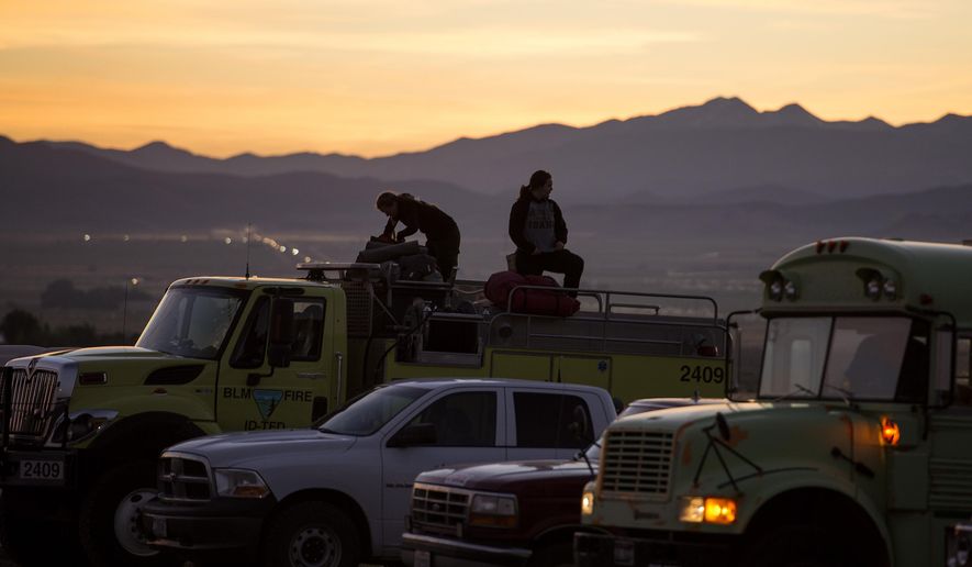 From left, Twin Falls, Idaho, firefighters Tenli Bright and Kori Neiwirth get ready to roll out for the day on the fire line, Parawan, Utah, Monday, June 19, 2017. Utah firefighters were battling a wildfire Monday that shut down a highway and forced hundreds of people to flee a ski town as crews in New Mexico mop up another blaze amid scorching heat in the Southwest U.S. (Leah Hogsten/The Salt Lake Tribune via AP)