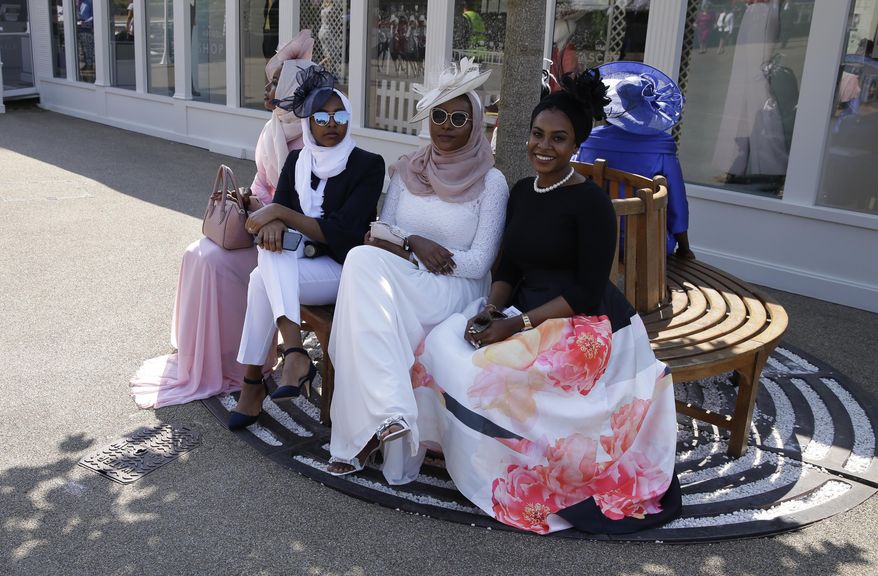 Racegoers keep to the shade as temperatures are expected to reach around 30 Celsius (86 degrees Fahrenheit) after arriving for the first day of the Royal Ascot horse race meeting in Ascot, England, Tuesday, June 20, 2017. (AP Photo/Alastair Grant)