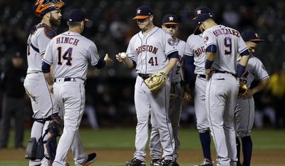 Houston Astros pitcher Brad Peacock (41) hands the ball to manager A.J. Hinch (14) as he is relieved in the sixth inning of a baseball game against the Oakland Athletics, Monday, June 19, 2017, in Oakland, Calif. (AP Photo/Ben Margot)