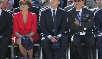 French President Emmanuel Macron, center, French defense minister Sylvie Goulard and Dassault Aviation CEO Eric Trappier, right, watch demonstration flights as part of the Paris Air Show in Le Bourget, north of Paris, Monday, June 19, 2017. Macron landed Monday at the Bourget airfield in an Airbus A400-M military transport plane to launch the aviation showcase, where the latest Boeing and Airbus passenger jets will vie for attention with a F-35 warplane, drones and other and high-tech hardware. (AP Photo/Michel Euler, Pool)
