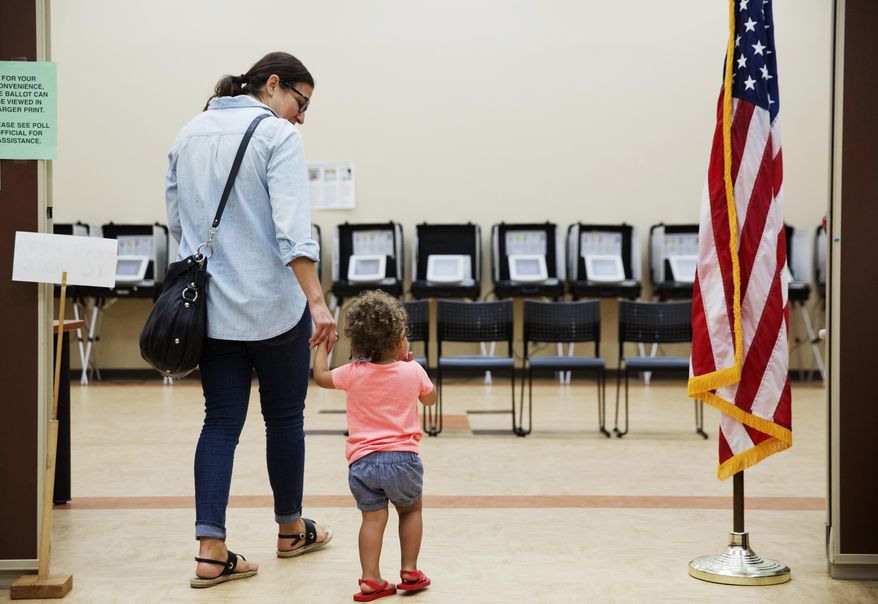 Melissa Painter walks with her one year-old daughter Elle to vote in Georgia's 6th Congressional District special election at a polling site in Sandy Springs, Ga., Tuesday, June 20, 2017. The most expensive House race in U.S. history heads to voters Tuesday in suburban Atlanta. Either Republican Karen Handel will claim a seat that's been in her party's hands since 1979 or Democrat Jon Ossoff will manage an upset that will rattle Washington ahead of the 2018 midterm elections. (AP Photo/David Goldman)