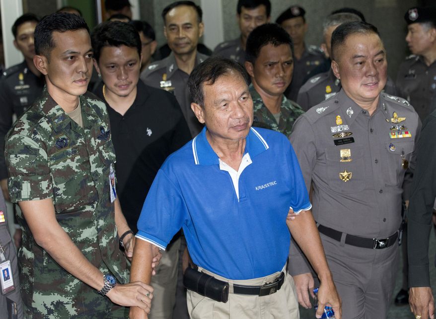Wattana Pumret, 61, is escorted by officials as he arrives at police headquarters for a press conference in Bangkok, Thailand, Tuesday, June 20, 2017. Wattana, who was arrested for the bombing of an army hospital in Bangkok, says he carried out the attack that wounded 21 people to symbolize defiance against Thailand&#39;s ruling military junta. (AP Photo/Sakchai Lalit)