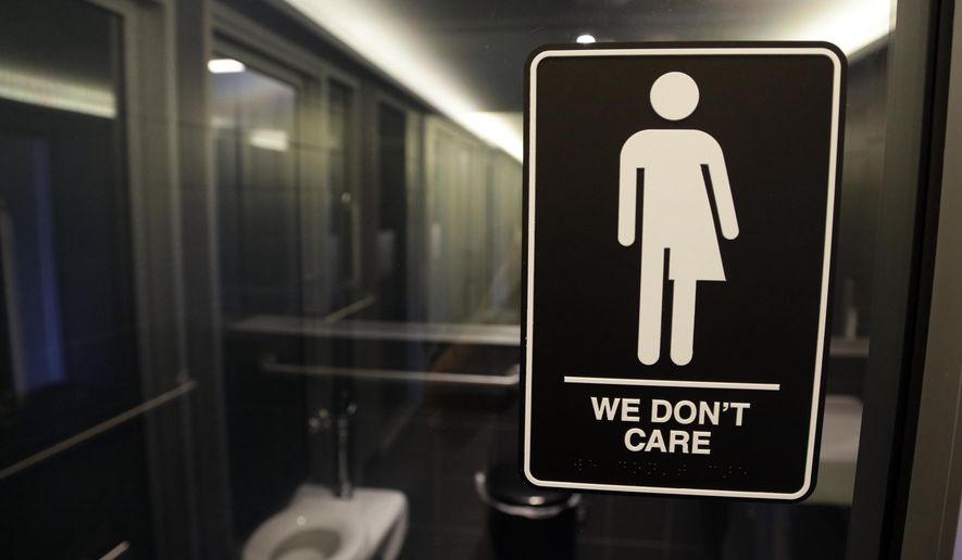 In this Thursday, May 12, 2016 file photo, signage is seen outside a restroom at the 21c Museum Hotel in Durham, N.C. In North Carolina, PayPal and Deutsche Bank cancelled expansion plans and other companies reconsidered their investments in the state after it implemented a measure regarding transgender people, similar to what Montana is considering placing on their 2018 fall ballot. (AP Photo/Gerry Broome, File)