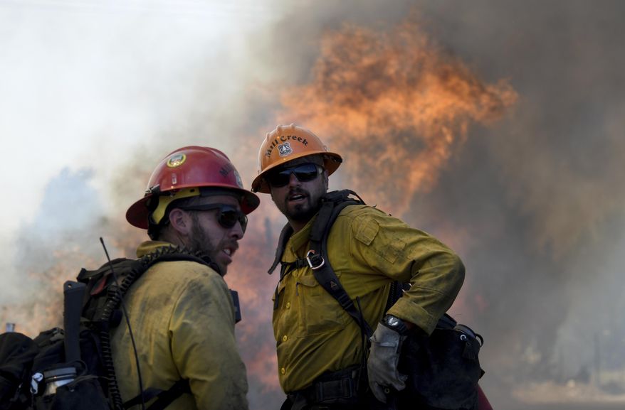 Members of the Mill Creek Hot Shots prepare to battle a wildfire near Big Bear, Calif., Tuesday, June 20, 2017. Mandatory evacuations have been called for homes as a wildfire burns in the San Bernardino Mountains east of Los Angeles. (James Quigg/The Daily Press via AP)