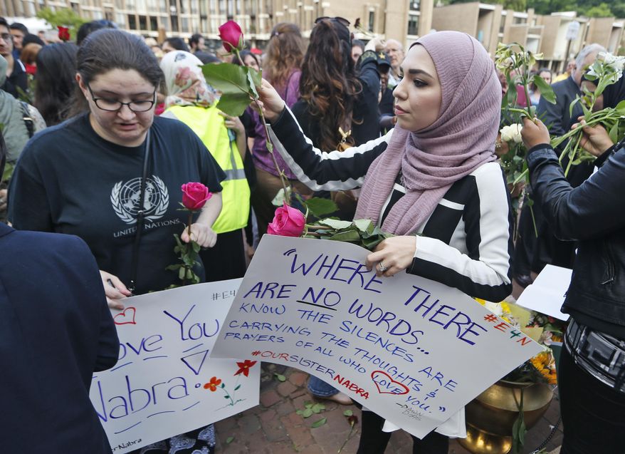 Supporters of Nabra Hassanen, who was killed over the weekend in a road rage incident, hand out flowers prior to the start of a vigil in honor of Nabar Wednesday, June 21, 2017, in Reston, Va. About 5,000 mourners attended Wednesday's funeral of Nabre, a Muslim girl whose beating death, blamed by police on a motorist's road rage, has some people in her community fearing for their safety. (AP Photo/Steve Helber)