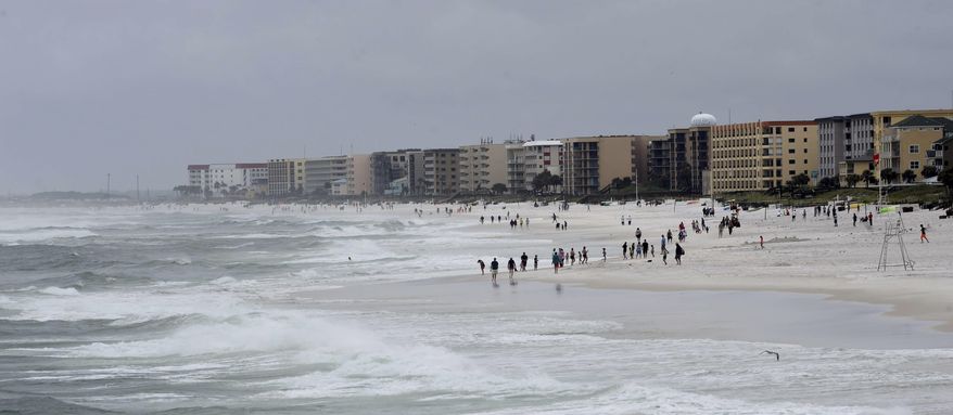 Beachgoers walk along Okaloosa Island near Fort Walton Beach, Fla., on Tuesday, June 20, 2017. Tropical Storm Cindy has churned up the Gulf of Mexico, causing high surf and heavy winds along coastal northwest Florida. (Devon Ravine/Northwest Florida Daily News via AP)
