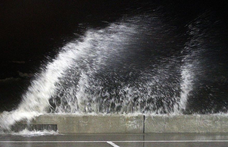 Waves crash into the seawall at the small craft harbor at Jones Park, in Gulfport, Miss., after midnight, Wednesday, June 21, 2017. High tide and rain from feeder bands from Tropical Storm Cindy moved through the coast. (Tim Isbell/The Sun Herald via AP)