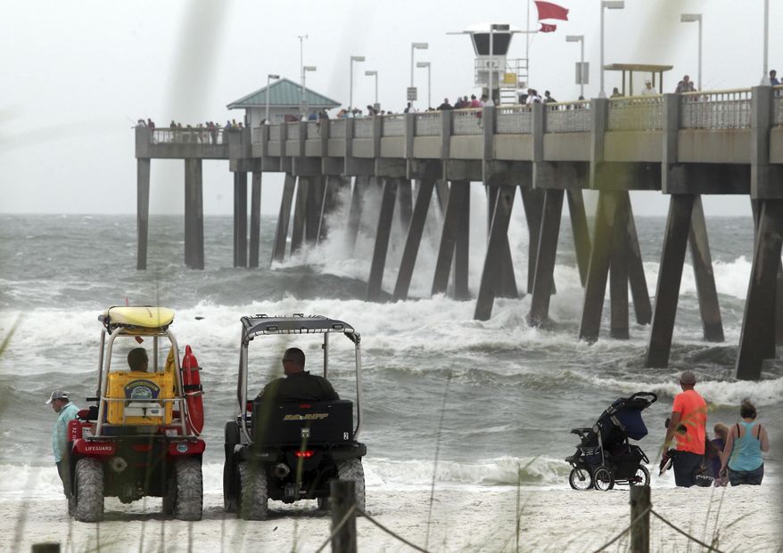 Authorities watch people near the water at the Okaloosa Pier as heavy surf brought on by Tropical Storm Cindy pounds the pier supports in Fort Walton Beach, Fla, Wednesday, June 21, 2017. (Michael Snyder/Northwest Florida Daily News via AP)