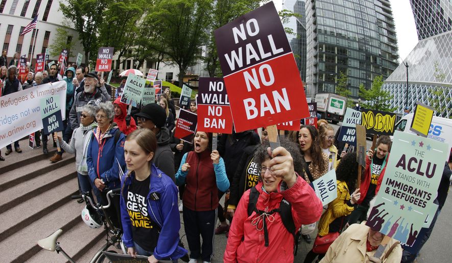 In this May 15, 2017, photo, protesters wave signs and chant during a demonstration against President Donald Trump&#39;s revised travel ban outside a federal courthouse in Seattle. A federal judge said Wednesday, June 21, 2017, that a class-action lawsuit challenging a once-secret government program that delayed immigration and citizenship applications by Muslims can move forward. (AP Photo/Ted S. Warren, file)