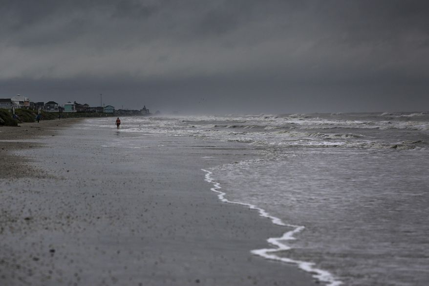 A woman walks along the beach the morning after Tropical Storm Cindy made landfall Thursday, June 22, 2017, on the Bolivar Peninsula, Texas. (Michael Ciaglo/Houston Chronicle via AP)