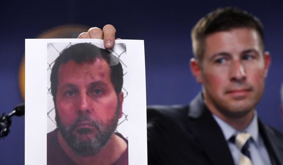 In this file photo, Timothy Wiley, FBI public affairs specialist, holds a photo Amor Ftouhi after a news conference in Detroit, Thursday, June 22, 2017. Amor Ftouhi, a Canadian man, shouted in Arabic before stabbing a police officer in the neck at the Bishop International Airport in Flint, Mich., federal officials said. (AP Photo/Paul Sancya) **FILE**