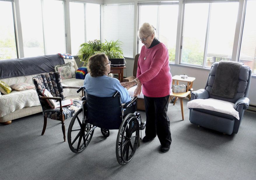 ADVANCE FOR USE SUNDAY, JUNE 25 - In this June 1, 2017 photo, Sister Clarissa Goeckner, right, visits with Sister Cecile Marie Uhlorn at the Monastery of St. Gertrude near Cottonwood, Idaho, where Sr. Clarissa is being cared for by her fellow Benedictine sisters. Looking at a photo album is a welcome trip through her past. (Barry Kough /Lewiston Tribune via AP, File)