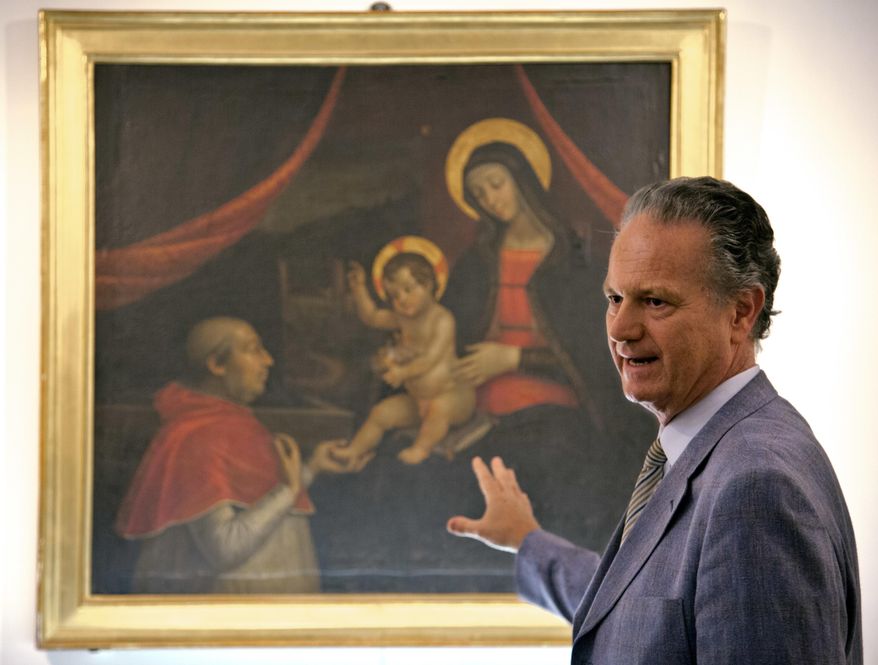 Former director of the Vatican Museums Francesco Buranelli speaks in front of a copy by Pietro Facchetti of Renaissance master Pintoricchio's mural panting depicting Borgia Pope Alexander VI on his knees before Baby Jesus held by the Virgin Mary that was decorating a private chamber in the Borgia papal apartment at the Vatican, part of the exhibition "Pintoricchio. Painter of the Borgias. The mistery of Giulia Farnese revealed." on display at the Capitoline Museums in Rome, Thursday, June 22, 2017. (AP Photo/Domenico Stinellis)