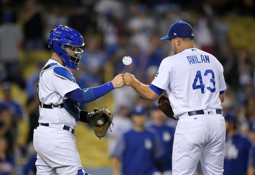 Los Angeles Dodgers catcher Yasmani Grandal, left, and relief pitcher Luis Avilan congratulate each other after the Dodgers defeated the New York Mets 8-2 in a baseball game, Wednesday, June 21, 2017, in Los Angeles. (AP Photo/Mark J. Terrill)