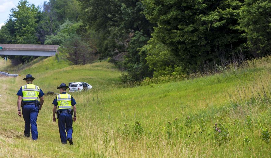 In this Wednesday, June 21, 2017 photo, Michigan state police officers works the scene of a crash on U.S. 131, which caused multiple critical injuries, in Kalamazoo, Mich. (Carly Geraci /Kalamazoo Gazette-MLive Media Group via AP)