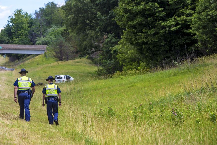 In this Wednesday, June 21, 2017 photo, Michigan state police officers works the scene of a crash on U.S. 131, which caused multiple critical injuries, in Kalamazoo, Mich. (Carly Geraci /Kalamazoo Gazette-MLive Media Group via AP)