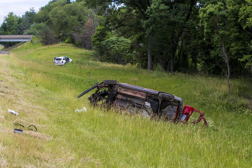 In this Wednesday, June 21, 2017 photo, a vehicle lies on its side at the scene of a crash on U.S. 131, which caused multiple critical injuries, in Kalamazoo, Mich. (Carly Geraci /Kalamazoo Gazette-MLive Media Group via AP)