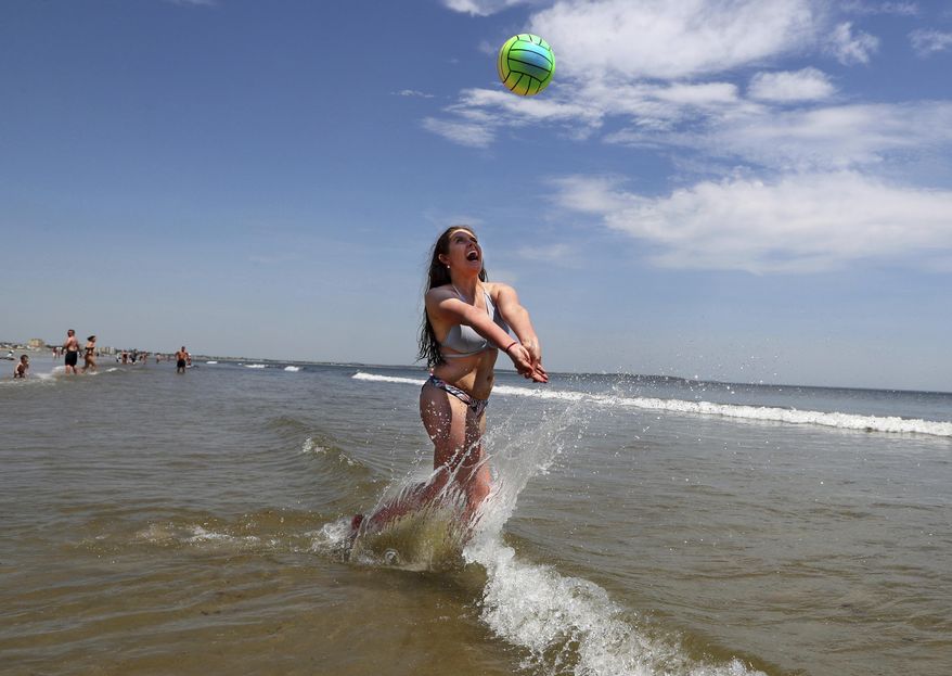 FILE - In this May, 18, 2017, file photo, Nessa King of Wyndham, Maine, returns a shot while playing volleyball in record breaking heat at Old Orchard Beach, Maine. As a summer vacation destination, Maine has something for everyone, from hiking and beaches to adventure and the arts. (AP Photo/Robert F. Bukaty, File)