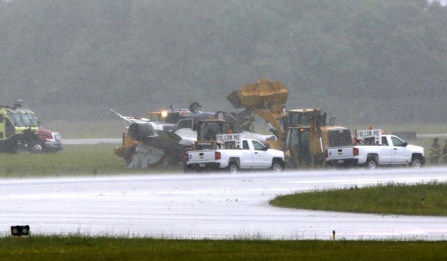 A military jet is attended to after flipping over at the Dayton International Airport on Friday, June 23, 2017, in Dayton, Ohio. (Ty Greenlees /Dayton Daily News via AP)