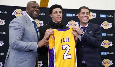 Los Angeles Lakers&#39; Lonzo Ball, center, poses for photos with Magic Johnson, left, and general manager Rob Pelinka during a news conference, Friday, June 23, 2017, in El Segundo, Calif. (AP Photo/Jae C. Hong)