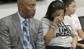Mary Dawes, center, becomes emotional while lawyer Daryl Washington, left, speaks at a news conference Friday, June 23, 2017, in Dallas. Dawes&#39; daughter, Genevive, who was pregnant at the time, was fatally shot by a Dallas police officer in January. A grand jury has recommended an aggravated assault charge against the officer. (AP Photo/Jaime Dunaway)