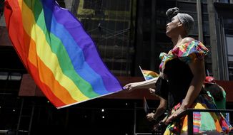 In this June 24, 2014, file photo, people on a float dance and wave flags during the annual pride parade in New York. The annual pride parade takes place on Sunday, June 25, 2017, amid protests by black and brown LGBT people saying increasingly corporate pride celebrations prioritize the experiences of gay white men and ignore the issues continuing to face black and brown LGBT people. (AP Photo/Seth Wenig, File)