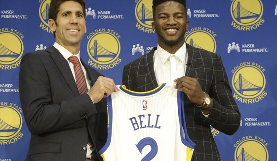 Golden State Warriors NBA basketball draft pick Jordan Bell, right, and general manager Bob Myers pose for photos with a jersey at a news conference in Oakland, Calif., Friday, June 23, 2017. (AP Photo/Jeff Chiu)