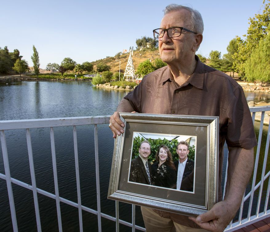 In this Friday, June 23, 2017 photo, Frank Kerrigan holds onto a photograph of his three children John, Carole, and Frank, near Wildomar, Calif. Kerrigan, who thought his son Frank had died, learned he buried the wrong man. Kerrigan said the Orange County coroner's office mistakenly identified a body found dead on May 6 as that of his son. (Andrew Foulk/The Orange County Register via AP)