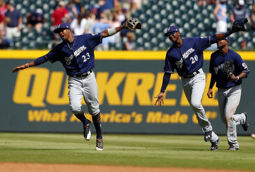 Milwaukee Brewers center fielder Keon Broxton (23) and Lewis Brinson (20) fly in from the outfield as they celebrate the 7-0 victory over the Atlanta Braves in a baseball game, Sunday, June 25, 2017, in Atlanta, Ga. (AP Photo/Butch Dill)