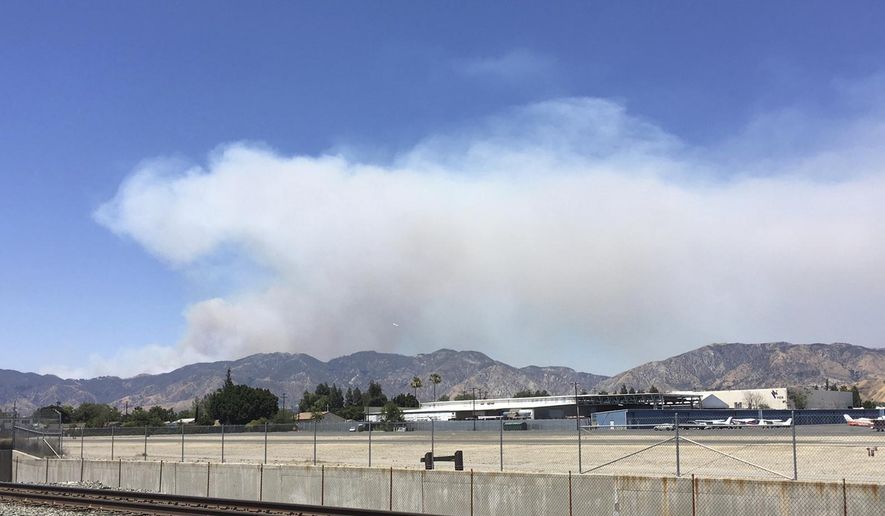A fast-growing brush fire burns in Santa Clarita, Calif., Sunday, June 25, 2017. The fire sparked when a car crashed on a Los Angeles County freeway. (AP Photo/John Antczak)