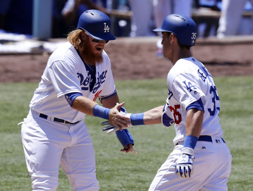 Los Angeles Dodgers' Cody Bellinger, right, celebrates with Justin Turner after a two-run home run against the Colorado Rockies during the third inning of a baseball game in Los Angeles, Sunday, June 25, 2017. (AP Photo/Chris Carlson)
