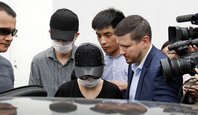 Unidentified Crown Resorts employees wearing face masks are escorted by securities as they leave the Baoshan District People&#x27;s Court after attending her trial in Shanghai, China, Monday, June 26, 2017. Australian and Chinese employees of a casino company on Monday pleaded guilty to charges relating to gambling and the three Australians were sentenced to nine or 10 months&#x27; imprisonment, an Australian official said. (AP Photo/Andy Wong)