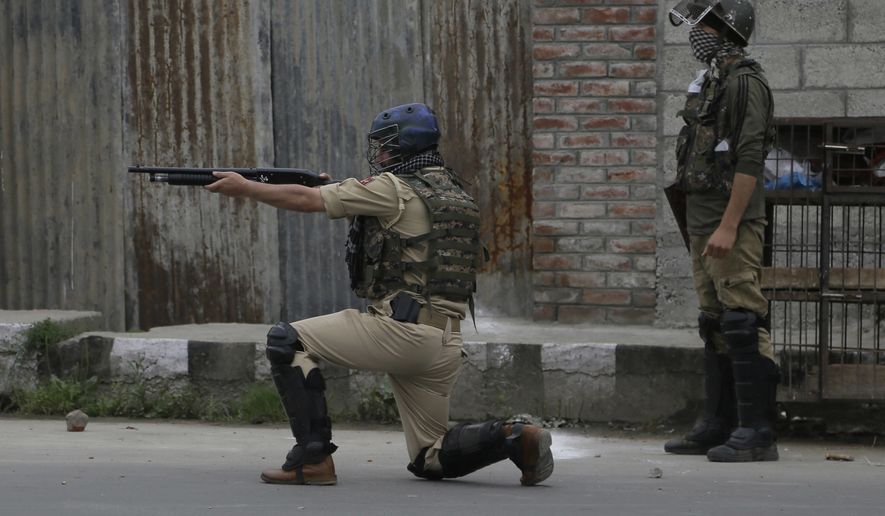 An Indian paramilitary force soldier fires a pellet gun during a protest after Eid al-Fitr prayers in Srinagar, Indian controlled Kashmir, Monday, June 26, 2017. Indian forces used tear gas and pellet guns to disperse hundreds of stone-throwing protesters who took to the streets after Eid al-Fitr prayers protesting Indian rule on Monday. (AP Photo/Mukhtar Khan)