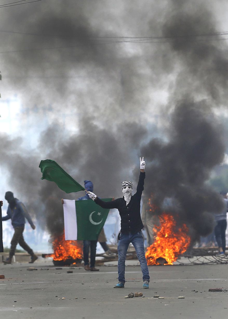 A Kashmiri Muslim protester shows Pakistani flag and shouts anti Indian slogans during a protest after Eid al-Fitr prayers in Srinagar, Indian controlled Kashmir, Monday, June 26, 2017. Indian forces used tear gas and pellet guns to disperse hundreds of stone-throwing protesters who took to the streets after Eid al-Fitr prayers protesting Indian rule on Monday. (AP Photo/Mukhtar Khan)