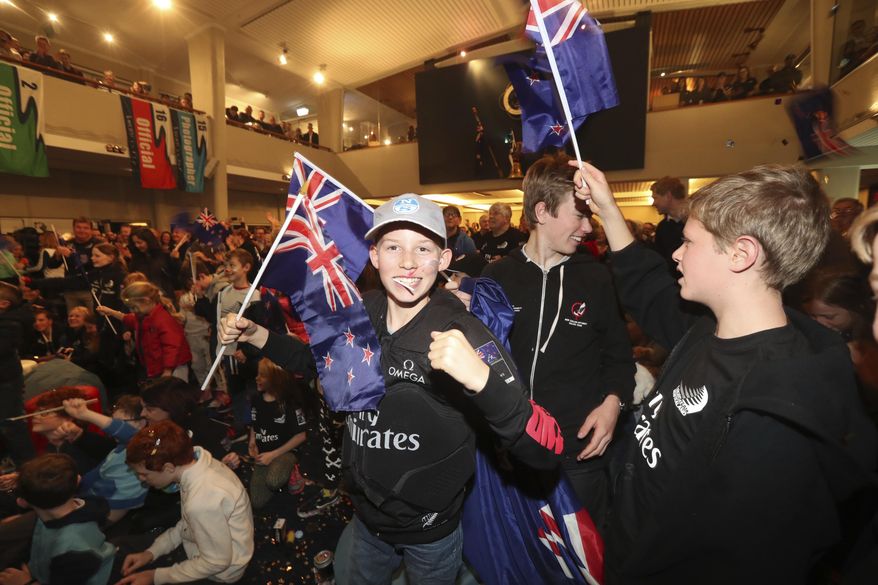 Fans of Emirates Team New Zealand celebrate in Auckland, New Zealand, Tuesday, June 27, 2017 after they defeated Oracle Team USA in the America's Cup in Hamilton, Bermuda. (Nick Reed/New Zealand Herald via AP)