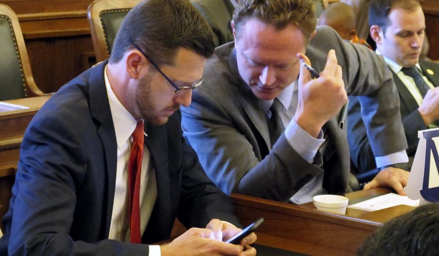 Kansas state Reps. John Wilson, left, D-Lawrence, and Tim Hodge, right, D-North Newton, talk during the House's brief session before lawmakers adjourned for the year, Monday, June 26, 2017, at the Statehouse in Topeka, Kan. Wilson said he plans to resign from the Legislature this fall for family reasons. (AP Photo/John Hanna)