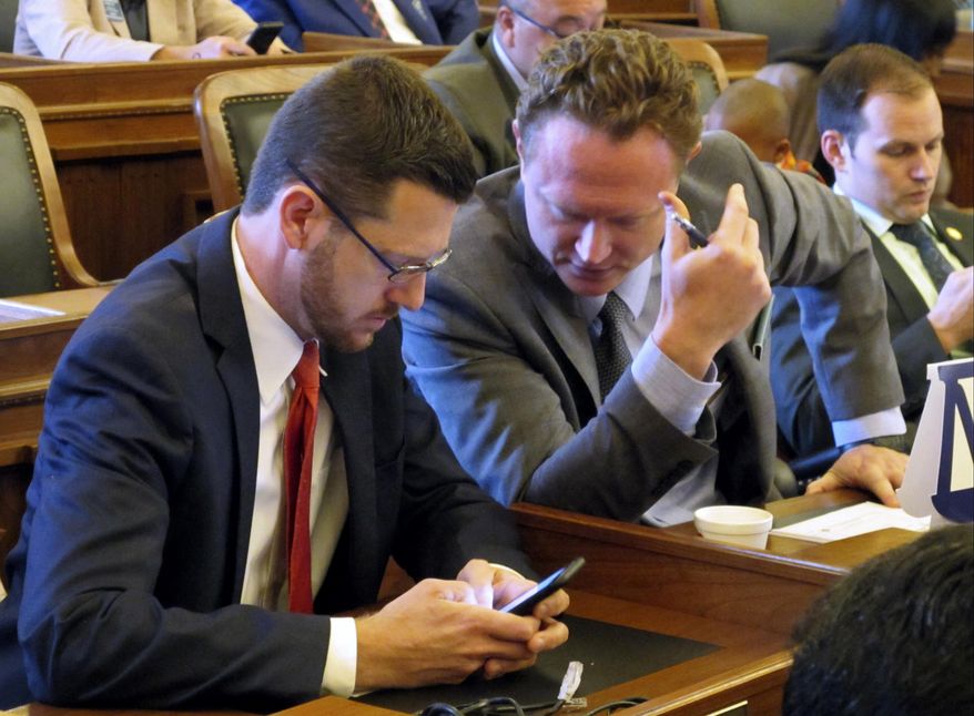 Kansas state Reps. John Wilson, left, D-Lawrence, and Tim Hodge, right, D-North Newton, talk during the House's brief session before lawmakers adjourned for the year, Monday, June 26, 2017, at the Statehouse in Topeka, Kan. Wilson said he plans to resign from the Legislature this fall for family reasons. (AP Photo/John Hanna)