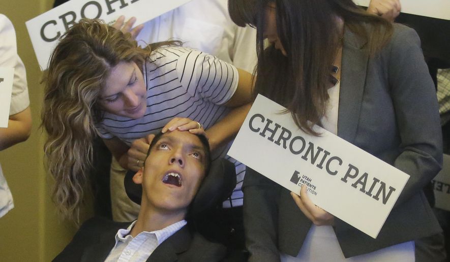 Desiree Hennessy, left, attends to her adopted son Hestevan, who has Cerebral Palsy and suffers from chronic nerve pain, seizure disorder during the Utah Patients Coalition news conference at the Utah State Capitol Monday, June 26, 2017, in Salt Lake City. A group of activists and Utah residents with chronic conditions has launched a ballot initiative to ask voters next year to pass a broad medical marijuana law. (AP Photo/Rick Bowmer)