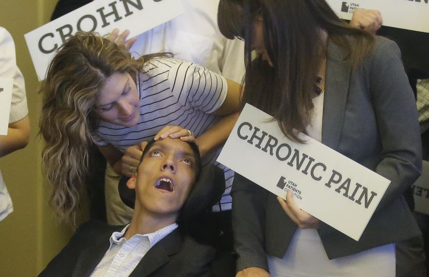 Desiree Hennessy, left, attends to her adopted son Hestevan, who has Cerebral Palsy and suffers from chronic nerve pain, seizure disorder during the Utah Patients Coalition news conference at the Utah State Capitol Monday, June 26, 2017, in Salt Lake City. A group of activists and Utah residents with chronic conditions has launched a ballot initiative to ask voters next year to pass a broad medical marijuana law. (AP Photo/Rick Bowmer)