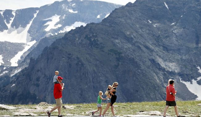 A family strolls the scenic overlook in Colorado's Rocky Mountain National Park. (Associated Press)